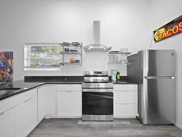 kitchen with appliances with stainless steel finishes, extractor fan, light hardwood / wood-style flooring, and white cabinets