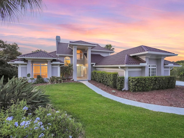 306 Marsh Point Cir, Saint Augustine, FL 32080 - view of front facade with stucco siding, a lawn, a chimney, and a tiled roof