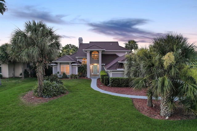 306 Marsh Point Cir, Saint Augustine, FL 32080 - mediterranean / spanish house featuring a chimney, a front yard, stucco siding, and a tile roof