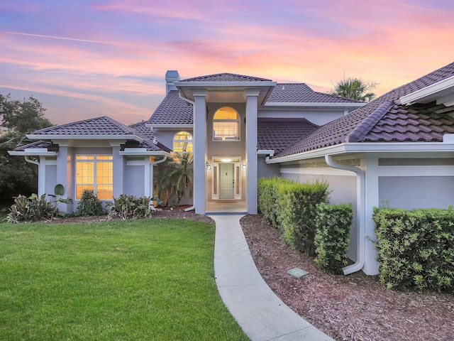 306 Marsh Point Cir, Saint Augustine, FL 32080 - view of front of house with a front yard, a chimney, stucco siding, and a tile roof
