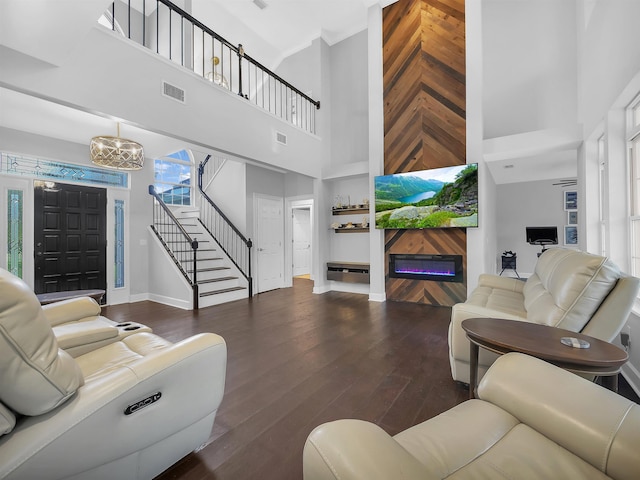 306 Marsh Point Cir, Saint Augustine, FL 32080 - living area with a towering ceiling, stairway, a glass covered fireplace, a chandelier, and wood finished floors