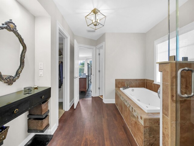 306 Marsh Point Cir, Saint Augustine, FL 32080 - bathroom featuring a whirlpool tub, wood finished floors, a walk in closet, a shower stall, and a chandelier