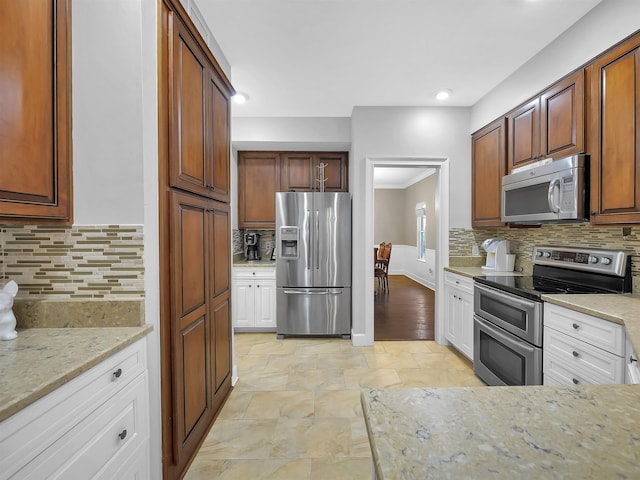 306 Marsh Point Cir, Saint Augustine, FL 32080 - kitchen with stainless steel appliances, backsplash, light stone counters, light stone finish floors, and recessed lighting