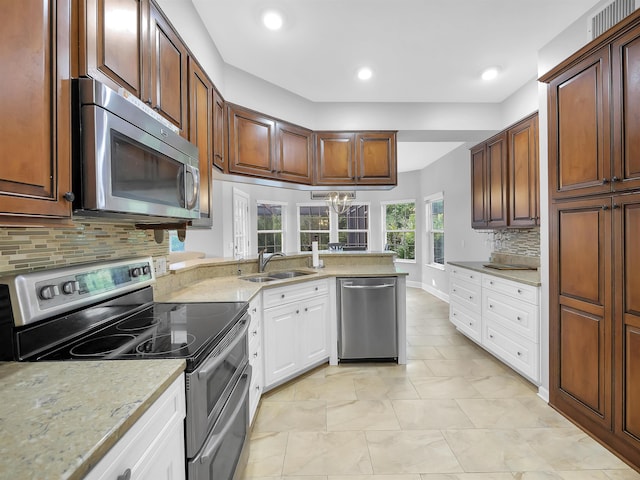 306 Marsh Point Cir, Saint Augustine, FL 32080 - kitchen featuring appliances with stainless steel finishes, tasteful backsplash, white cabinetry, light stone countertops, and recessed lighting