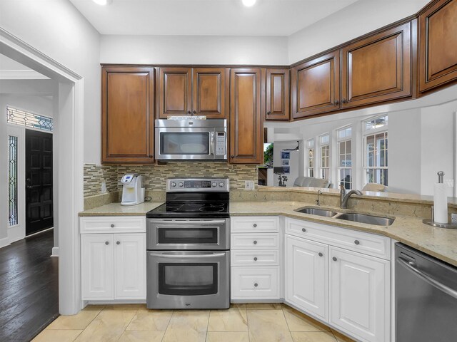 306 Marsh Point Cir, Saint Augustine, FL 32080 - kitchen featuring appliances with stainless steel finishes, light stone counters, decorative backsplash, and white cabinetry