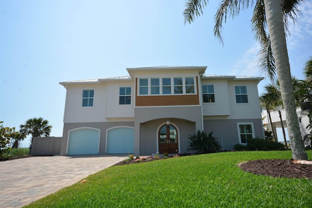 view of front of home with a garage, a front lawn, and french doors