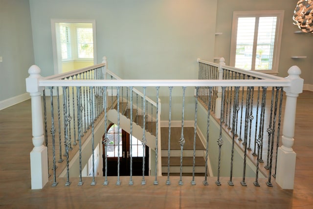 stairway featuring wood-type flooring and a healthy amount of sunlight