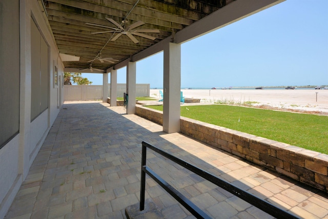 view of patio with a water view and ceiling fan