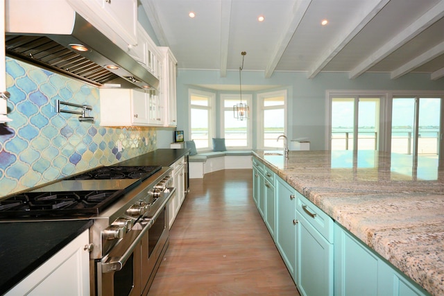 kitchen featuring white cabinets, extractor fan, beamed ceiling, double oven range, and a water view