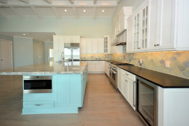 kitchen with wine cooler, a spacious island, white cabinetry, beam ceiling, and high end appliances