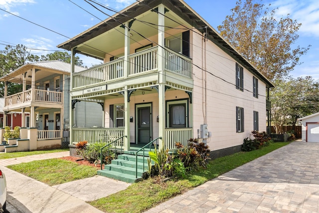 view of front of home with a garage, a porch, and a balcony