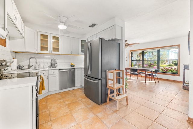 kitchen featuring visible vents, a sink, stainless steel appliances, ceiling fan, and tasteful backsplash