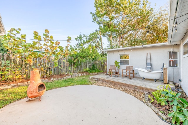 view of patio with a wooden deck and fence