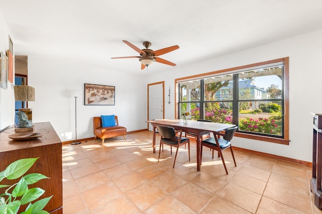 dining area with light tile patterned floors, baseboards, and ceiling fan