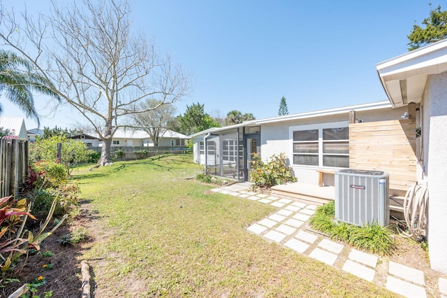 view of yard with cooling unit, a fenced backyard, and a sunroom