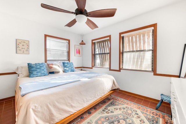 bedroom with tile patterned floors, baseboards, and ceiling fan