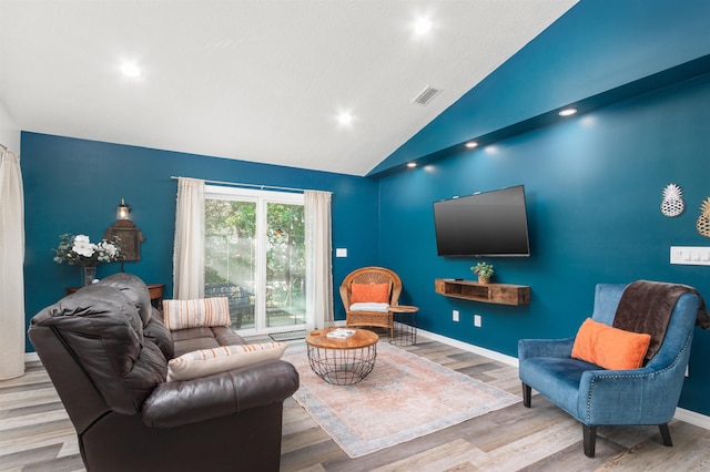 living room with high vaulted ceiling and light hardwood / wood-style flooring