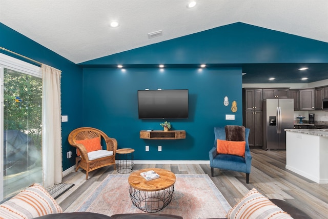 living room with vaulted ceiling and light hardwood / wood-style floors