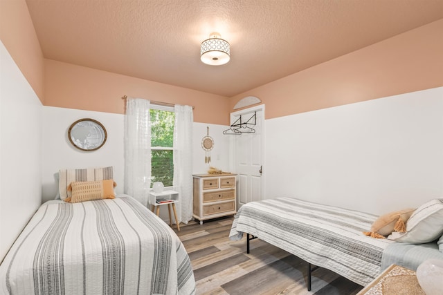 bedroom with hardwood / wood-style flooring and a textured ceiling