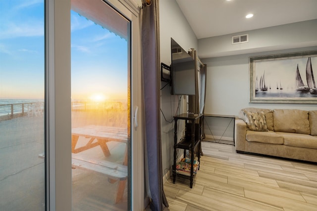 living room with light hardwood / wood-style floors and a water view