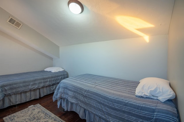 bedroom with lofted ceiling and dark wood-type flooring