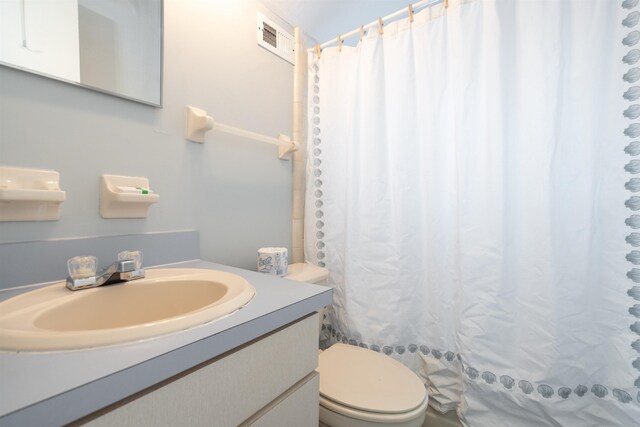 bathroom featuring vanity, toilet, and curtained shower