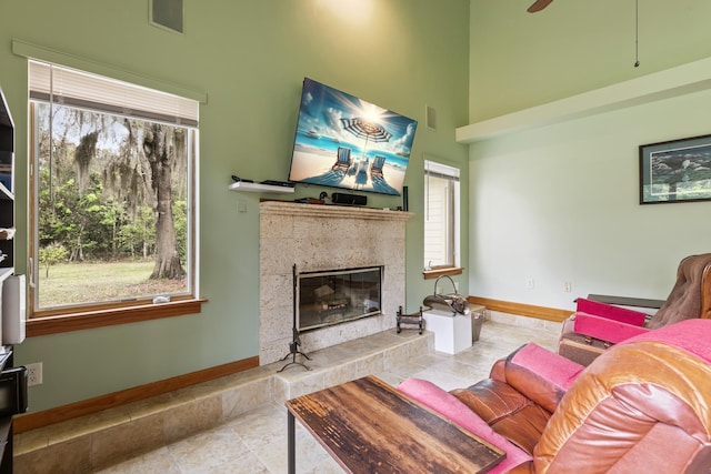 living room with tile patterned flooring, visible vents, a fireplace, and baseboards