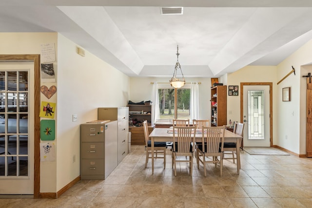 dining room with visible vents, baseboards, and a raised ceiling