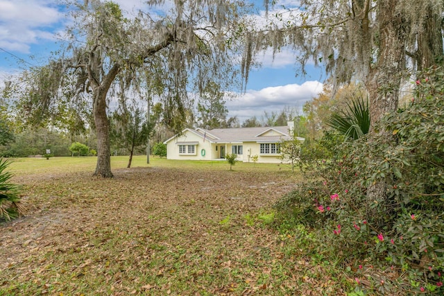 view of front of property with a chimney and a front lawn