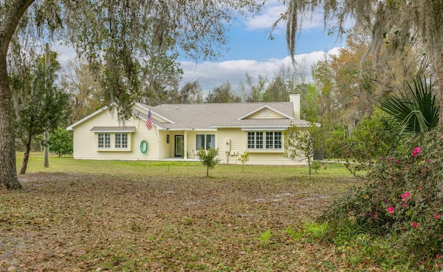 ranch-style house with a front lawn and a chimney