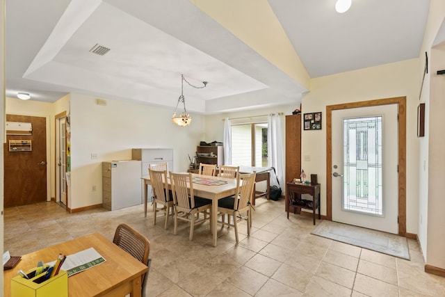 dining area featuring a raised ceiling, visible vents, baseboards, and light tile patterned flooring