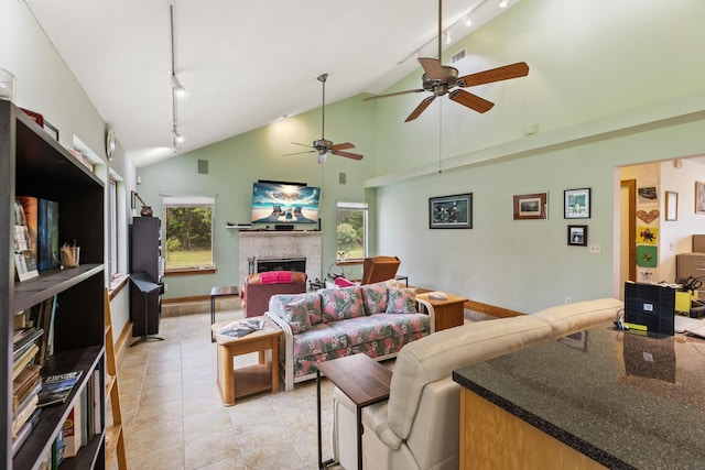 living room featuring a fireplace, light tile patterned floors, visible vents, track lighting, and high vaulted ceiling