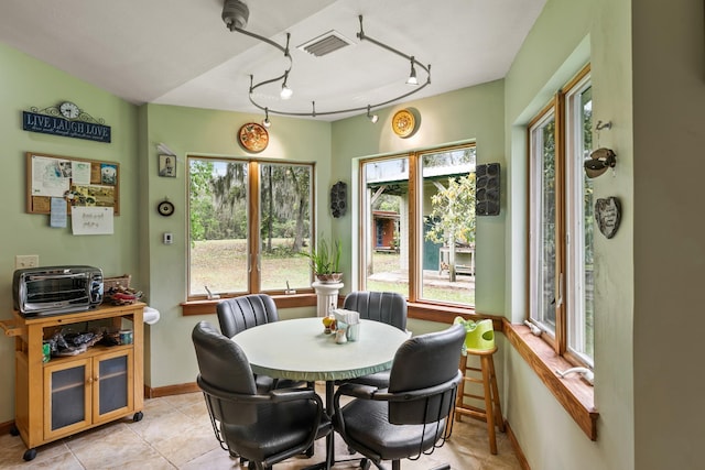 dining room featuring a toaster, baseboards, visible vents, and light tile patterned flooring