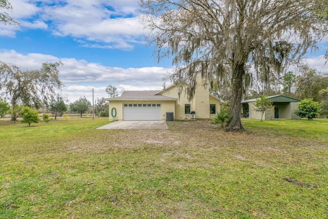 exterior space with a front lawn, concrete driveway, central AC, and an attached garage