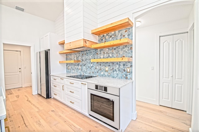 44 Cold Spring Ct, Palm Coast, FL 32137 - kitchen featuring open shelves, oven, freestanding refrigerator, black electric stovetop, and light wood-style flooring