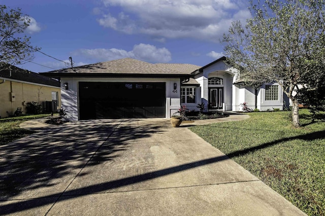 ranch-style house with a garage, driveway, a shingled roof, stucco siding, and a front yard