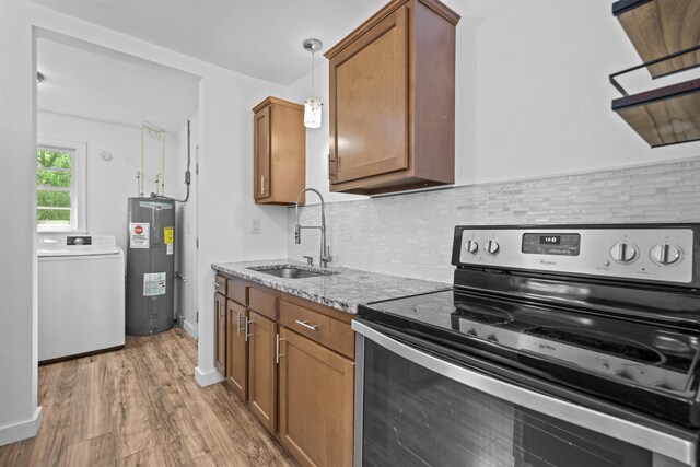 1617 Cleveland Ave, Palatka, FL 32177 - kitchen with stainless steel electric stove, water heater, washer / clothes dryer, a sink, and brown cabinets