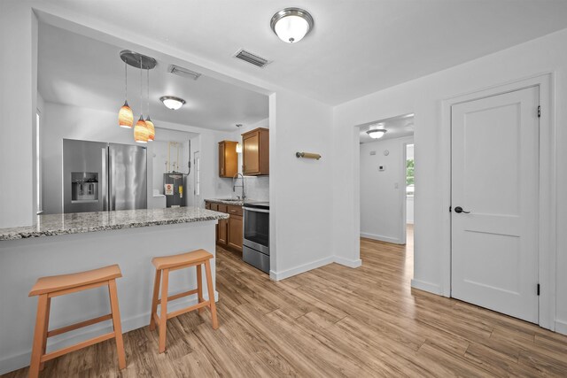 1617 Cleveland Ave, Palatka, FL 32177 - kitchen featuring stainless steel appliances, light wood-style floors, brown cabinets, and a sink