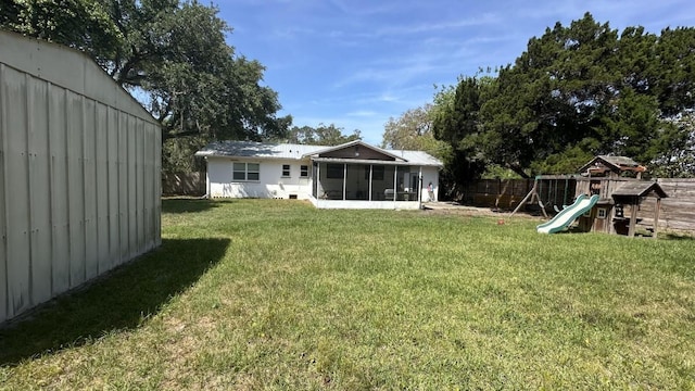 4208 Vermont Blvd, Elkton, FL 32033 - back of house featuring a fenced backyard, a yard, a sunroom, and a playground