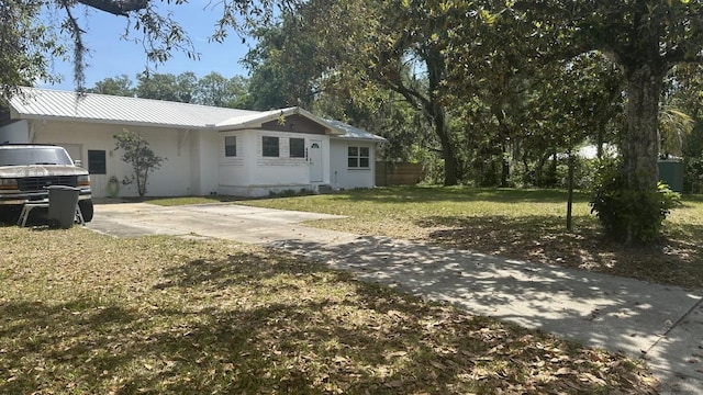 4208 Vermont Blvd, Elkton, FL 32033 - view of front of house featuring driveway, metal roof, and a front lawn