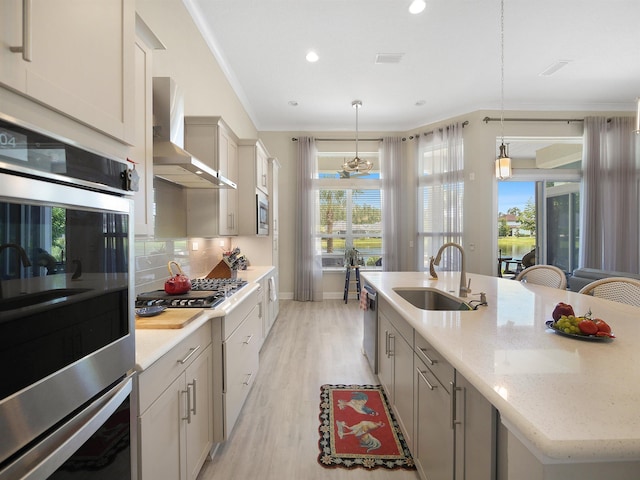 100 Coppinger Pl, Saint Johns, FL 32259 - kitchen with wall chimney exhaust hood, appliances with stainless steel finishes, light wood-type flooring, decorative backsplash, and recessed lighting