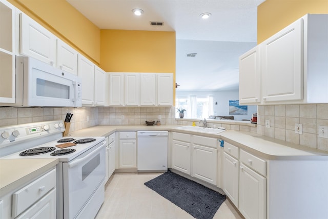 kitchen featuring sink, white appliances, white cabinetry, and decorative backsplash