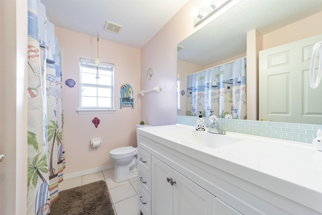 bathroom with tile patterned flooring, vanity, toilet, and backsplash