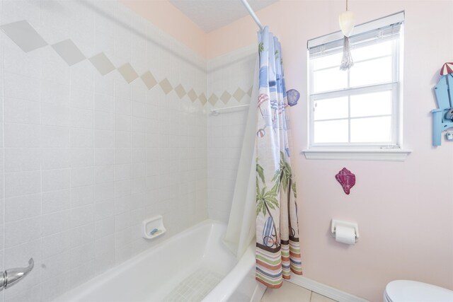 bathroom with toilet, tile patterned floors, and shower / bath combo with shower curtain