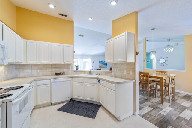 kitchen with sink, kitchen peninsula, white appliances, and white cabinets