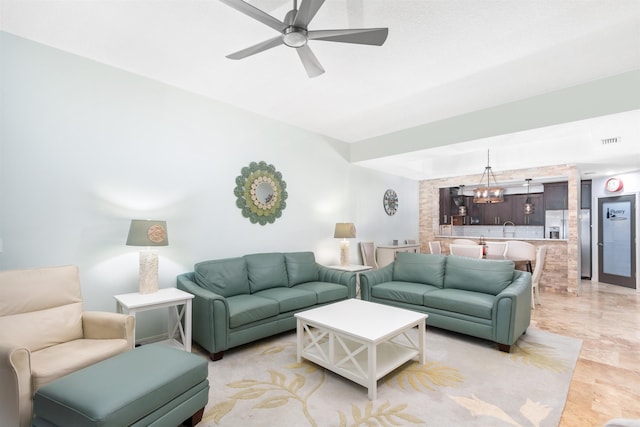 living room featuring sink and ceiling fan with notable chandelier