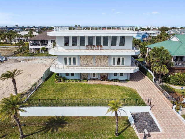 view of front of house featuring a balcony and a front yard