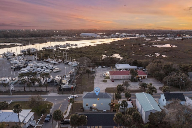 aerial view at dusk featuring a water view