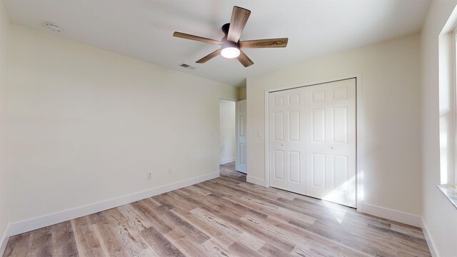 unfurnished bedroom featuring a closet, light hardwood / wood-style floors, and ceiling fan