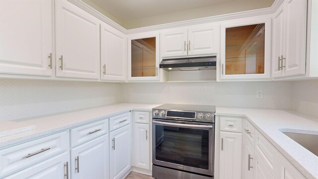 kitchen with white cabinetry, light stone counters, and electric stove